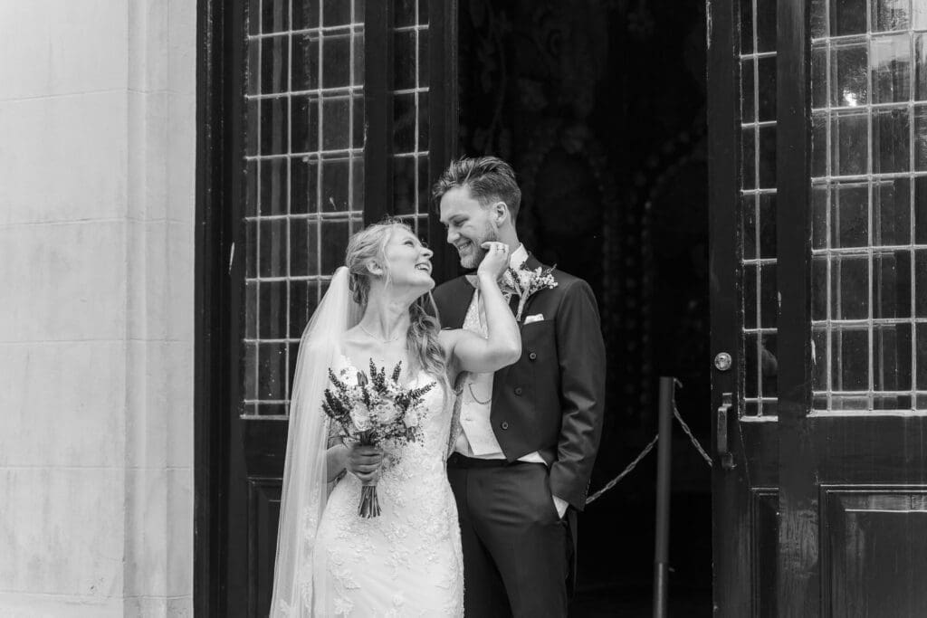 trouwfotograaf groningen bruidspaar lachend bij ceremonie ingang zwart wit foto